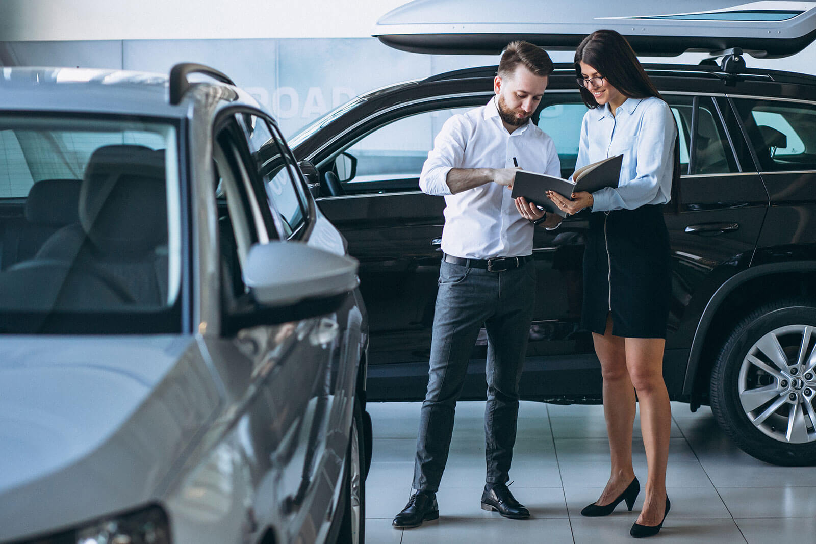 Salesman woman looking car car showroom
